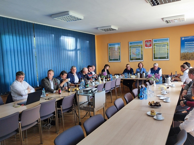 Siedzący przy stole goście słuchają wykładu dyrektor SDOO Beaty Kaliskiej