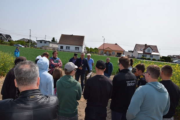 uczestnicy szkolenia słuchają wykładu przy poletkach doświadczalnych z rzepakiem ozimym