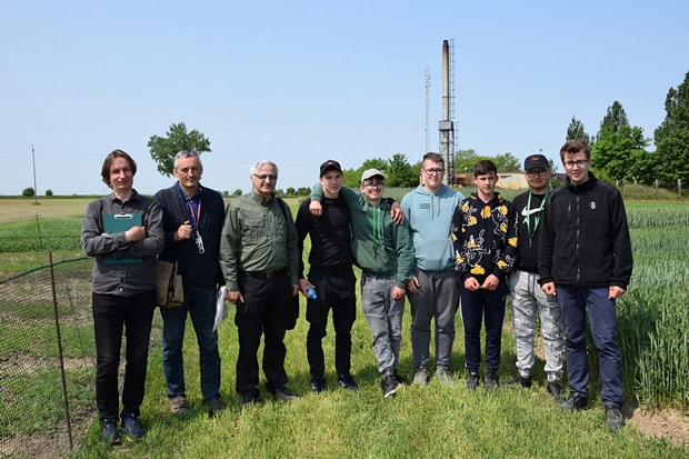zdjęcie grupowe uczestników szkolenia na ścieżce w kolekcji odmian zbóż i roślin bobowatych.