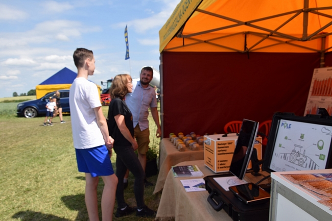 Rolnicy oglądający wystawę nasion soi i pszenicy ozimej przy namiocie SDOO