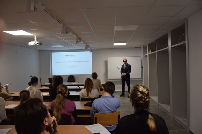 na pierwszym planie uczestnicy szkolenia na dalszym planie pracownik Stacji Daniel Krauklis podczas wygłaszania referatu