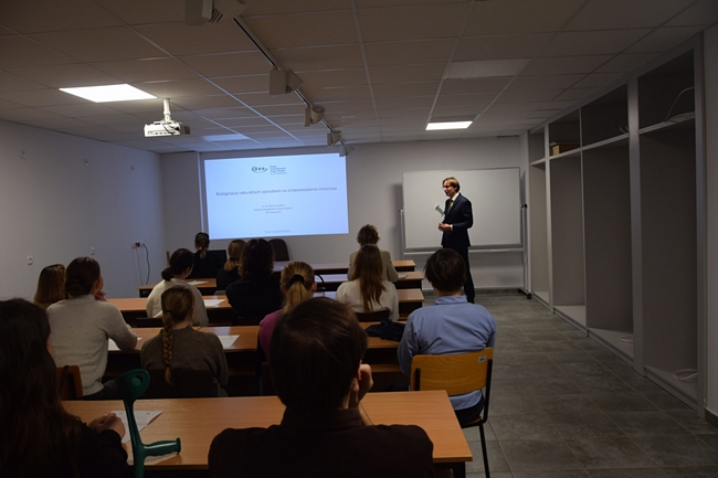 na pierwszym planie uczestnicy szkolenia na dalszym planie pracownik Stacji Daniel Krauklis podczas wygłaszania referatu