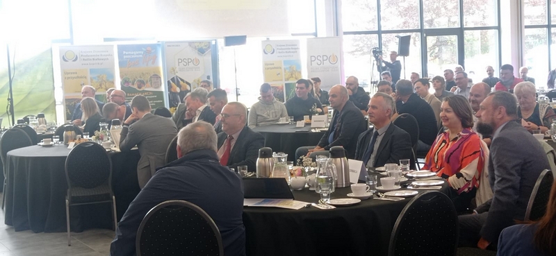 zaproszeni goście siedzący przy stołach na sali konferencyjnej 