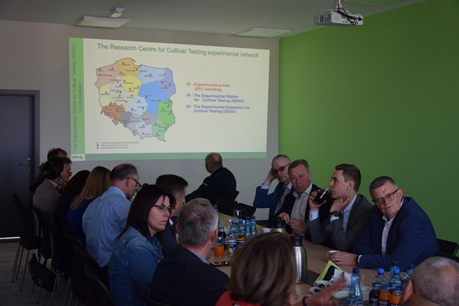 uczestnicy spotkania siedzący na stole na sali konferencyjnej  