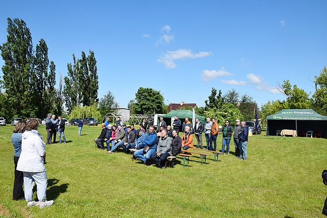 uczestnicy szkolenia siedzący na ławkach na trawniku